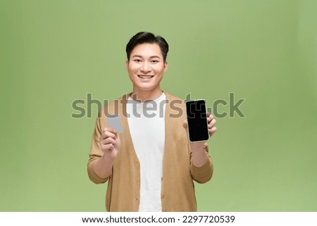 Photo of handsome positive guy demonstrate empty space display hold debit card 
