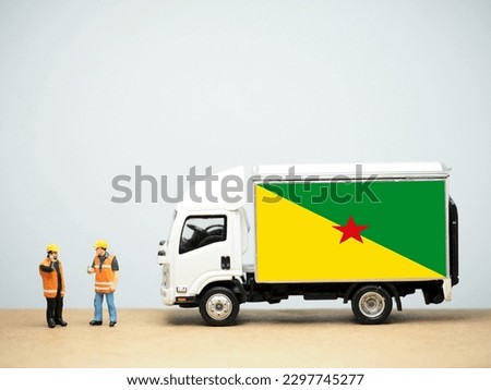 Mini toy at table with white background. Industrial shipping concept. French Guiana flag design, is an overseas department of France located on the northern coast of South America in the Guianas.