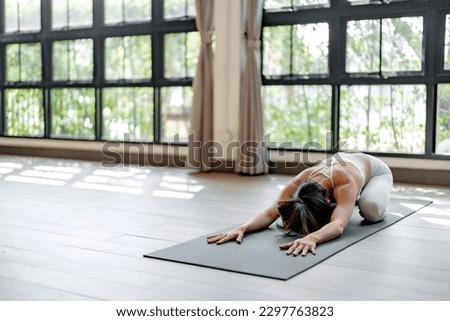 Fitness woman doing yoga exercise stretching on mat yoga, wellbeing lifestyle. Royalty-Free Stock Photo #2297763823