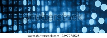 Blue digital binary data on computer screen with bokeh. Abstract information technology background. Digital binary code matrix background. Close-up with small dept