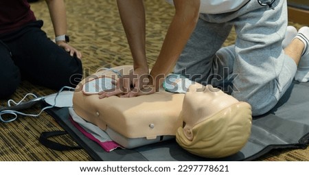 First aid cardiopulmonary resuscitation course using automated external defibrillator device - AED training. selective focus placing electrode Royalty-Free Stock Photo #2297778621