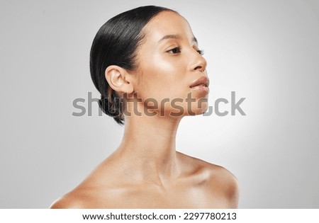 Her beauty is the centre of attention. Studio shot of an attractive young woman posing against a grey background. Royalty-Free Stock Photo #2297780213
