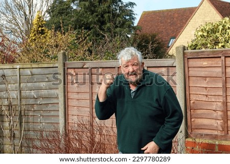 Angry old man shaking his fist and shouting. Royalty-Free Stock Photo #2297780289