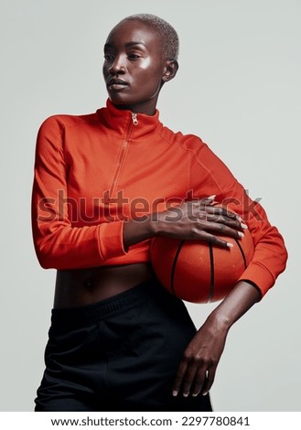 Basketball or nothing at all. Studio shot of an attractive young woman playing basketball against a grey background.
