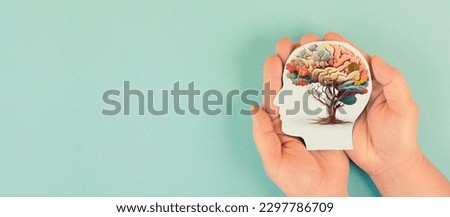 Hands holding paper head, human brain with flowers, self care and mental health concept, positive thinking, creative mind Royalty-Free Stock Photo #2297786709