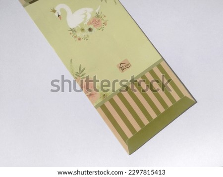 Envelopes containing money distributed during Eid with various cartoon character images to attract the attention of young children. Isolated white background.