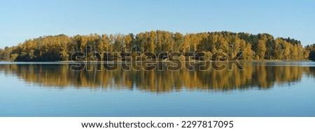Gold, green autumn landscape in the Russian countryside. Water in the lake is calm. Sun is everywhere in the october. Clear sky. Fresh cold air. Concept of the beauty in nature. Panoramic photography