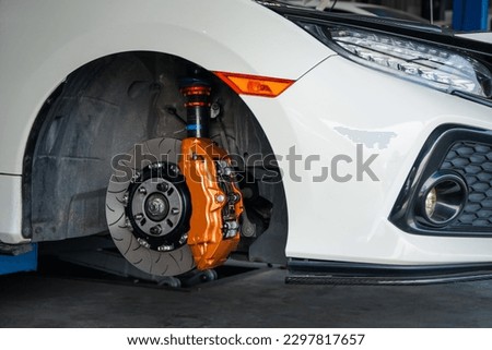 Car mechanic or serviceman disassembly and checking a disc brake and asbestos brake pads for fix and repair problem at car garage or repair shop Royalty-Free Stock Photo #2297817657