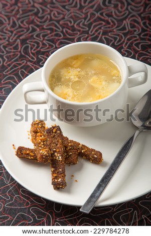 Bowl of soup with bread sticks on the table