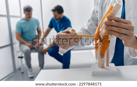 Treatment for knee injuries. Adult man with knee injury during consultation with doctor traumatologist at medical clinic Royalty-Free Stock Photo #2297848171