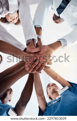 Another one for the team. Low angle shot of a group of doctors forming a huddle with their hands inside of a hospital during the day. Royalty-Free Stock Photo #2297853039