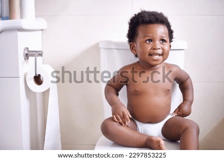 Baby boy, toilet and smile in house, learning and African childhood development with potty training. Young toddler, black child or kid sitting in bathroom with diaper, growth and happiness in home Royalty-Free Stock Photo #2297853225