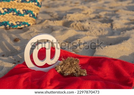 email icon on a red towel on the beach