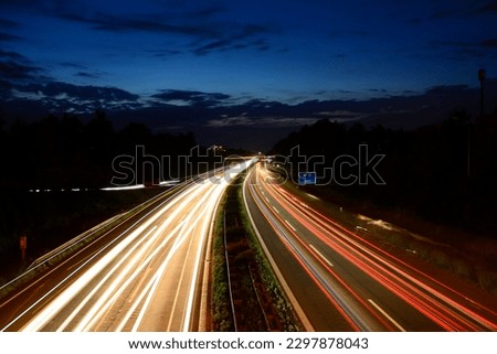 Headlights of cars on a long exposure on the highway at night. Abstract city background. Drone photo Royalty-Free Stock Photo #2297878043