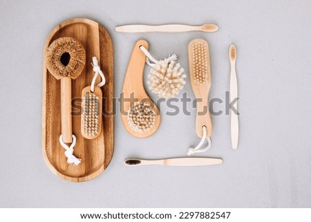 Set of brushes with wooden handles on a gray background, eco friendly products. Flat lay