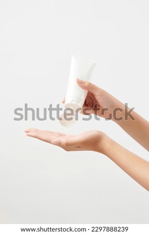 a woman's hand squeezing lotion into the palm of her hand Royalty-Free Stock Photo #2297888239