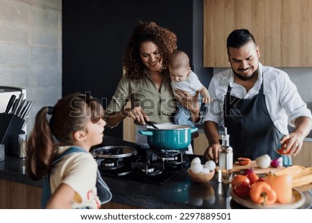 latin family cooking together with children daughter and son in kitchen at home in Mexico Latin America, hispanic people Royalty-Free Stock Photo #2297889501