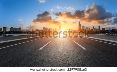 Straight asphalt road and city skyline with buildings scenery Royalty-Free Stock Photo #2297908163