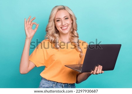 Photo of cute confident lady dressed orange t-shirt showing okey gesture texting modern gadget isolated teal color background