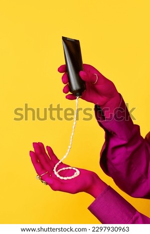Beauty procedures. Portrait of elegant female hands holding hand cream with jewelry inside over yellow background. Trash pop art, bright colors. Concept of beauty, fashion, creativity, self care, ad