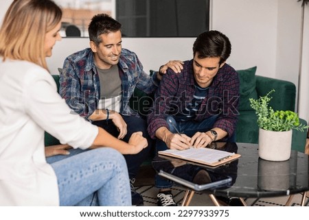Startup partners sign a loan agreement in the banking department. Financial adviser, to buy a house together gay couple Royalty-Free Stock Photo #2297933975