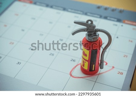 Fire extinguisher on calendar background with copy space. Concept of fire extinguisher education and training program appointment schedule in organization, office company, factory, school, etc. Royalty-Free Stock Photo #2297935601