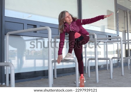 Senior adult woman exercising outdoors. Mature woman exercising