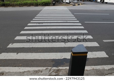 A zebra crossing (British English) or a marked crosswalk (American English) is a pedestrian crossing marked with white stripes (zebra markings).