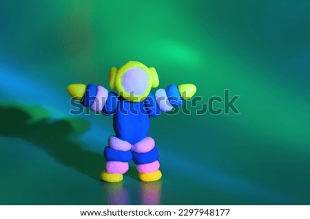 A toy astronaut on a greenish background. Space and science.