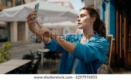 Young woman making selfie by the smartphone at street