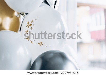 Happy birthday! Close up image of colorful helium glossy baloons on restaurant blur background. Luxury holiday flying decorations. Party template with place for your message. Copy space or empty space