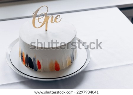 Happy birthday! Close up image first birthday sweet cake surprise number one inscription with burning candle
