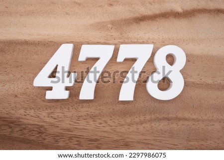 White number 4778 on a brown and light brown wooden background.