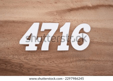 White number 4716 on a brown and light brown wooden background.