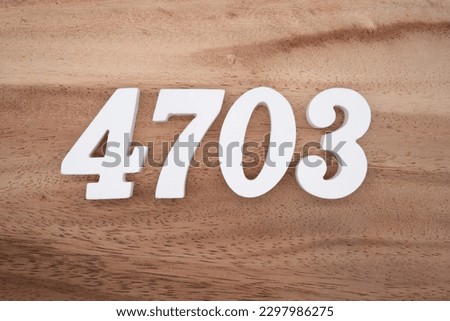 White number 4703 on a brown and light brown wooden background.