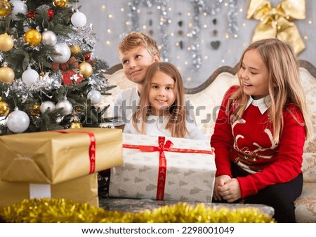 Two girls and boy holding gift in