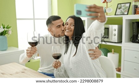 Man and woman couple make selfie by smartphone holding glass of wine at home
