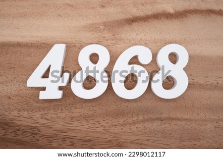White number 4868 on a brown and light brown wooden background.