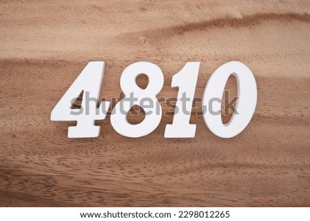 White number 4810 on a brown and light brown wooden background.