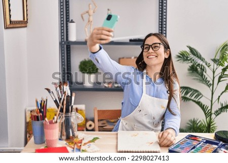 Young woman artist make selfie by the smartphone drawing on notebook at art studio