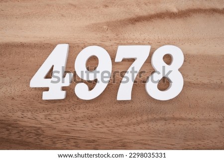 White number 4978 on a brown and light brown wooden background.