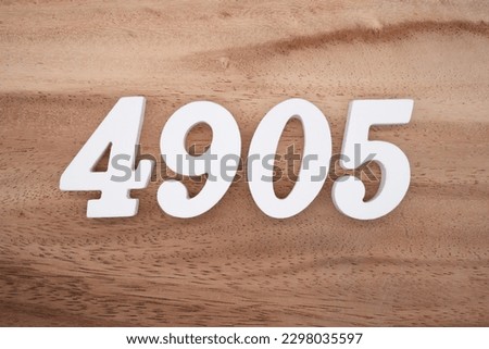 White number 4905 on a brown and light brown wooden background.
