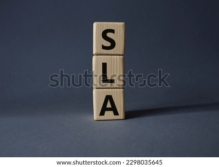 SLA - Service Level Agreement. Wooden cubes with word SLA. Beautiful grey background. Business and Service Level Agreement concept. Copy space.
