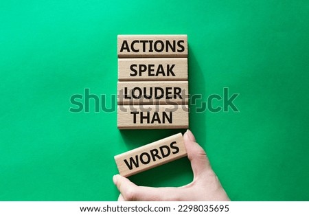 Actions speak louder than Words symbol. Wooden blocks with words Actions speak louder than Words. Beautiful green background. Businessman hand. Business and Actions concept. Copy space.