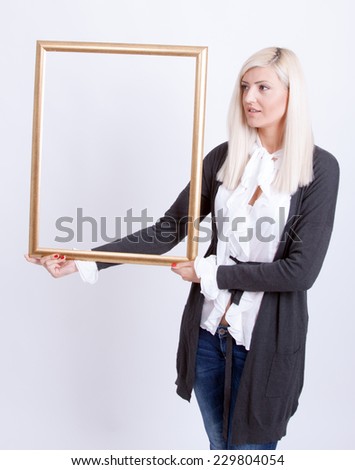 Portrait of a young blond woman holding a frame