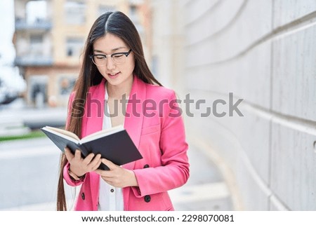 Chinese woman business worker reading book at street