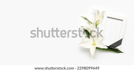 Blank funeral frame and lily flowers on white background with space for text Royalty-Free Stock Photo #2298099649