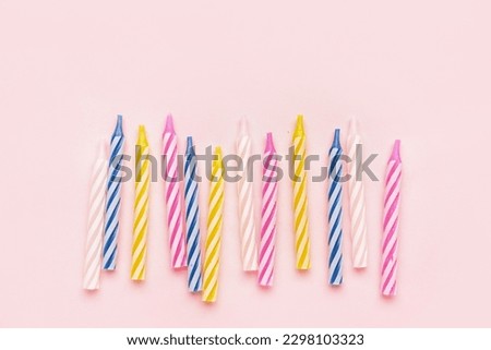 Colorful birthday candles on pink background
