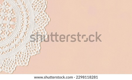 Part of a paper Cup Cake Doily on top of a pink paper. With space for your own text