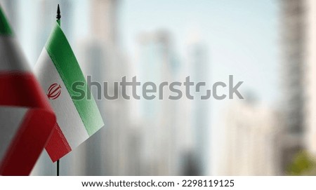 Small flags of the Iran on an abstract blurry background.